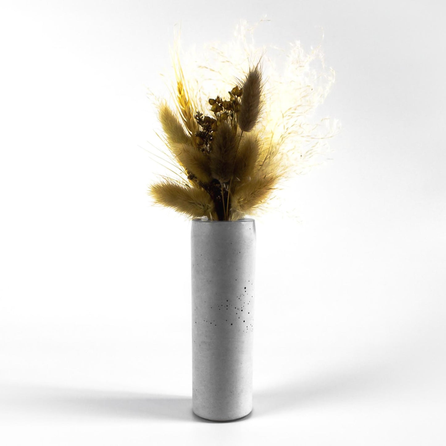 vase-fuer-trockenblumen-beton-rund-mit-blumen-frontal